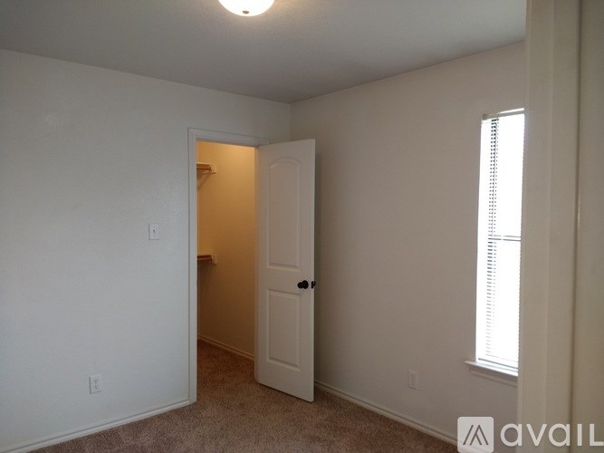 A room with a white door and a window with blinds.