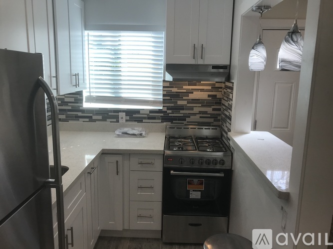 A kitchen with a stove top oven and a refrigerator.