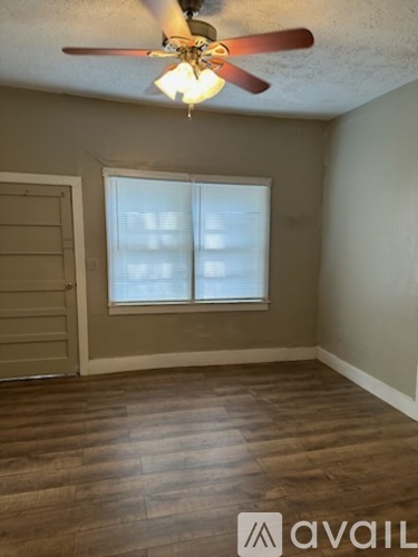 A room with a ceiling fan and a window.