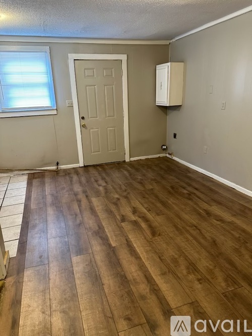 A room with a wooden floor and a white door.