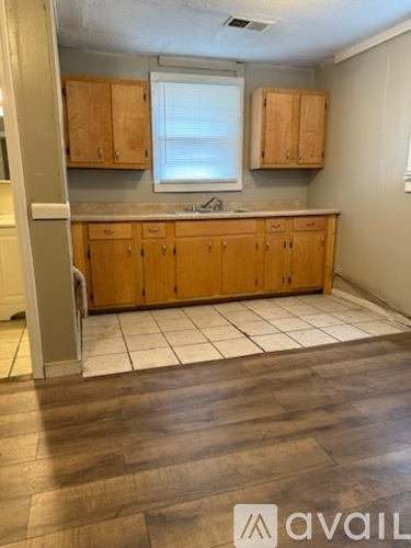 A kitchen with wooden cabinets and a window.