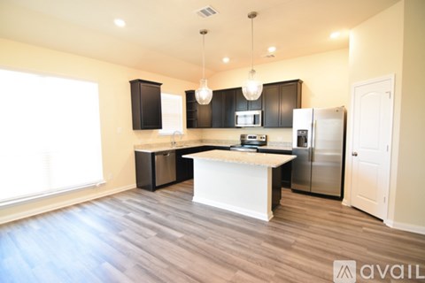 A kitchen with a white island and stainless steel appliances.