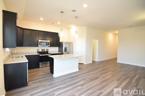 A modern kitchen with black cabinets and a white island.