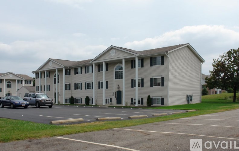 A large white building with a car parked in front.