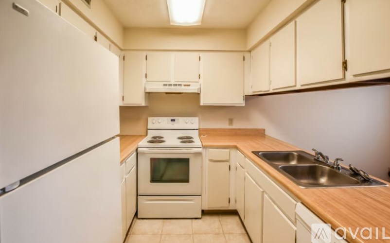 A kitchen with a white refrigerator, white oven, and white cabinets.