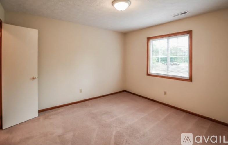 A room with a window and carpeted floor.