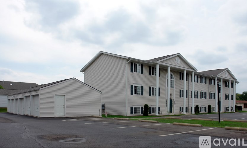 A large white building with a parking lot in front.