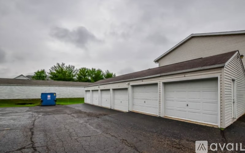 A row of white garage doors in front of a building.