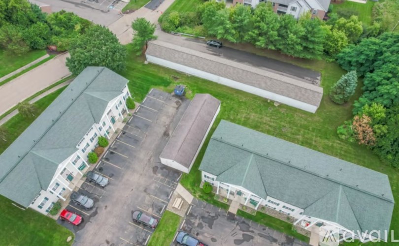 A parking lot with cars and a building with a green roof.