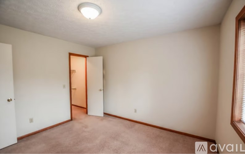 A room with a carpeted floor and a doorway leading to another room.