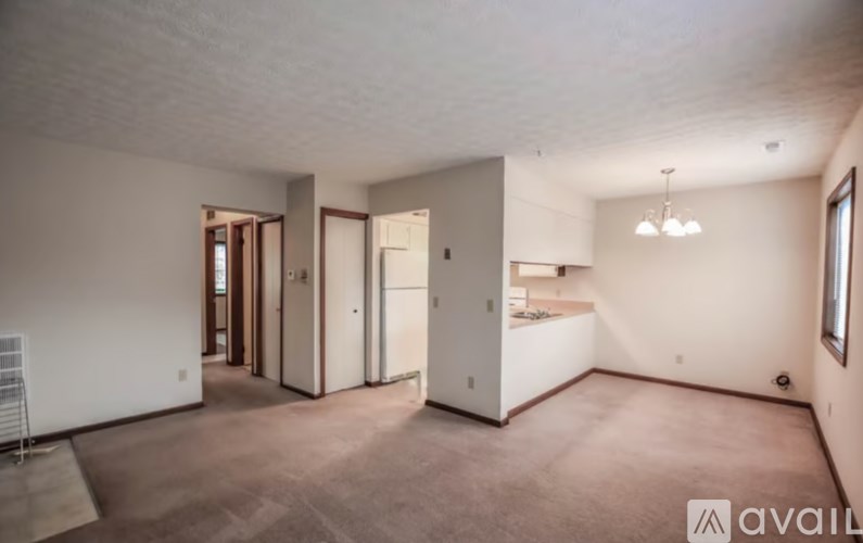 A spacious living room with a white cabinet and a window.
