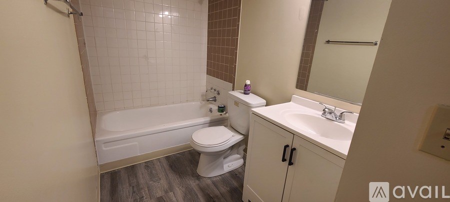A kitchen area with a sink, stove, and cabinets.