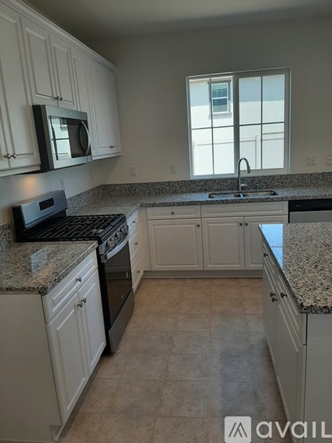 A kitchen with granite countertops and white cabinets.