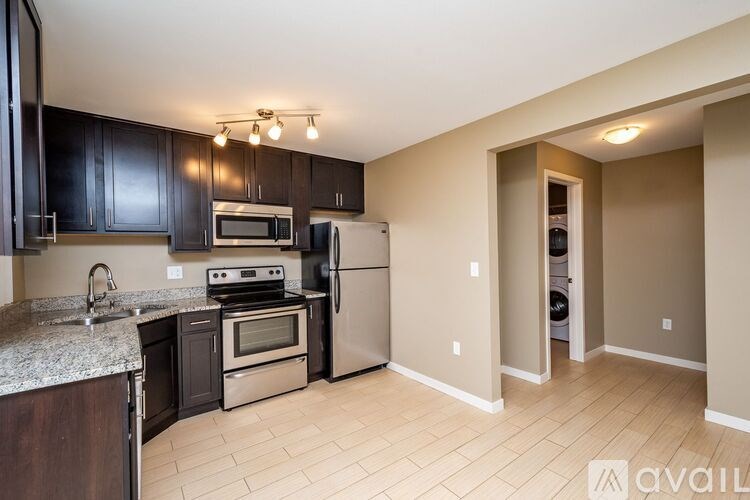 A kitchen with black cabinets and a granite countertop.