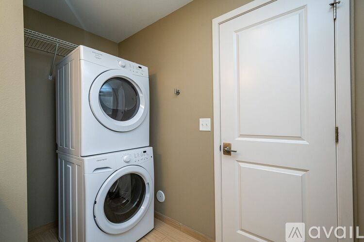 A stack of two white washing machines in a laundry room.
