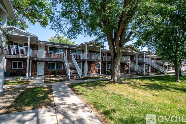 A row of apartment buildings with trees in front.