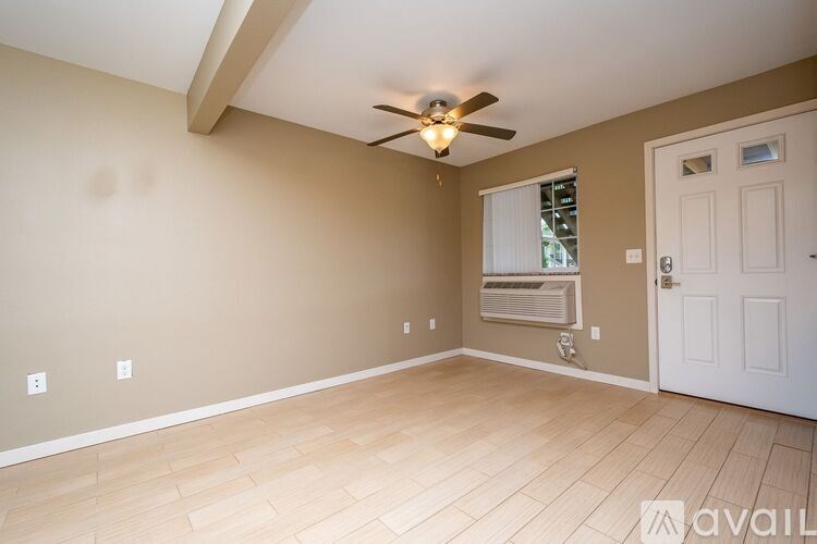 A room with a ceiling fan and a window with blinds.