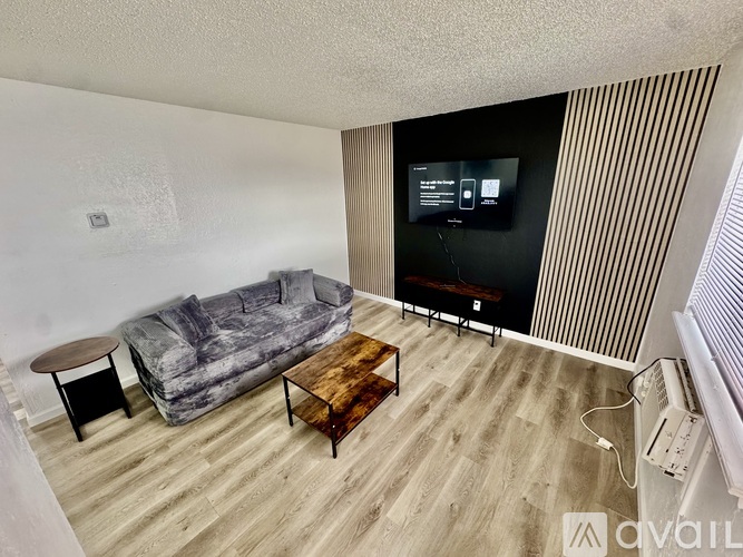 A room with wooden flooring and a window on the right side.