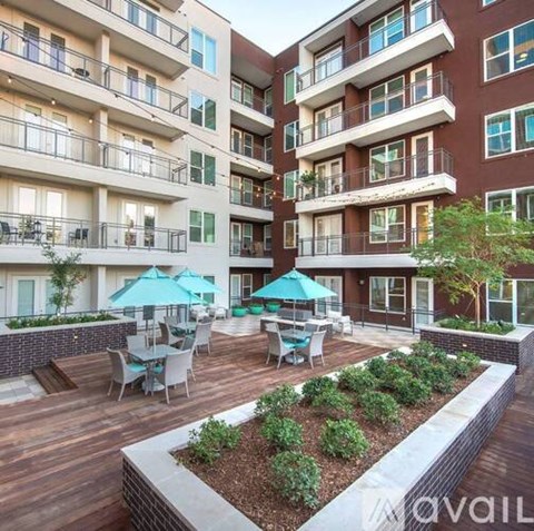 Apartment complex with a patio and seating area.