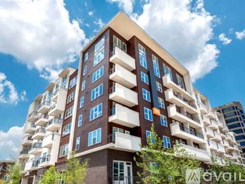 A tall apartment building with balconies on the upper floors.