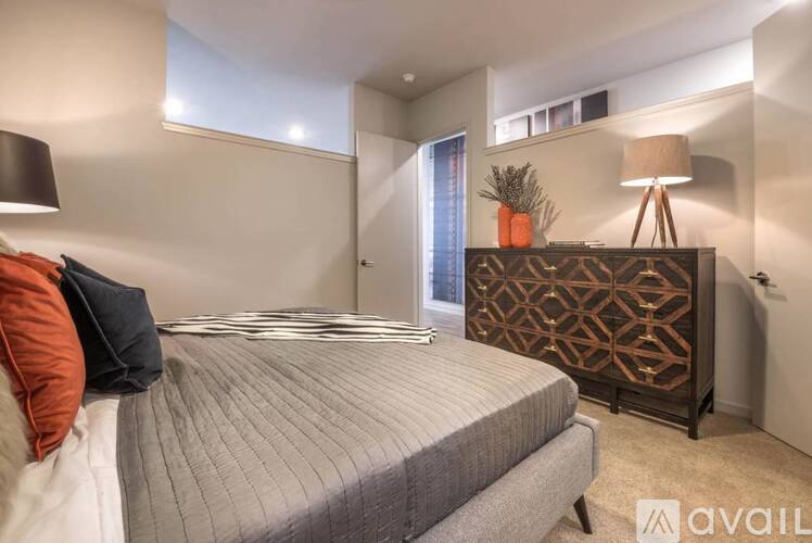 A bedroom with a bed, a lamp, and a decorative piece on the dresser.