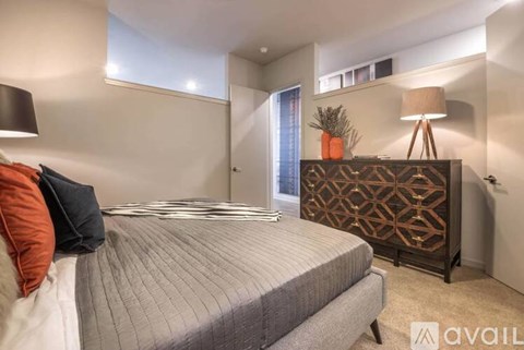 A bedroom with a bed, a lamp, and a decorative piece on the dresser.