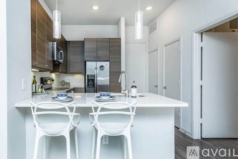 A modern kitchen with white chairs and a white table.