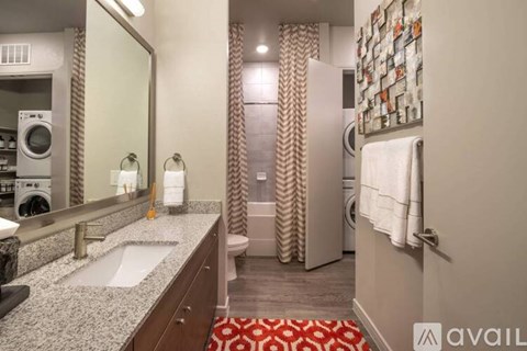 A bathroom with a washer and dryer in the corner.