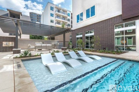 A pool with a slide and a building in the background.