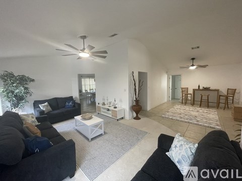 A living room with a black couch and a white coffee table.