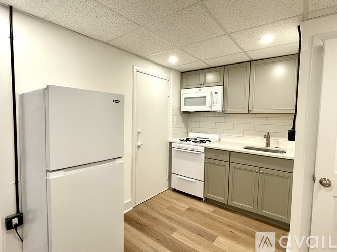 A kitchen with a white fridge, a white stove, and a white microwave.