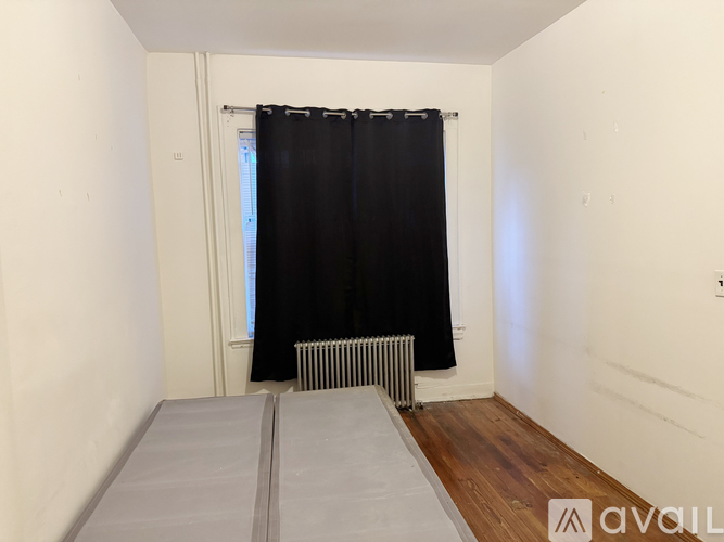 A room with a radiator and wooden floors.