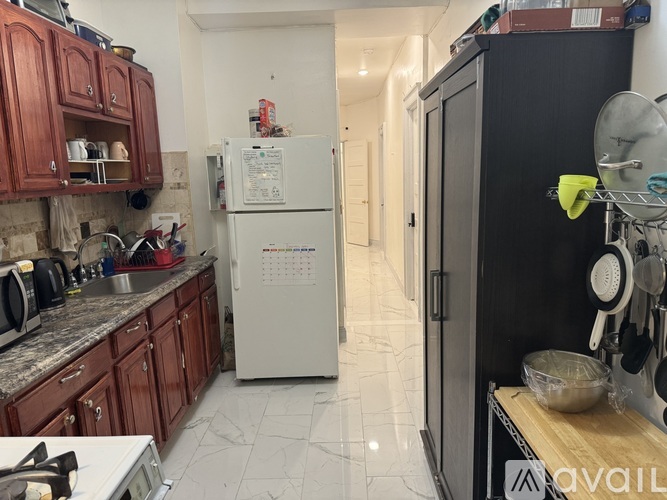 A kitchen with a white fridge and wooden cabinets.