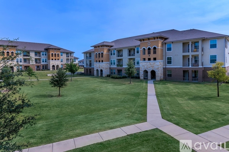 A large grassy area in front of apartment buildings.