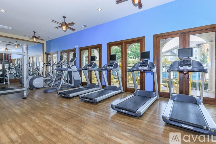 A gym with treadmills, elliptical machines, and other exercise equipment.