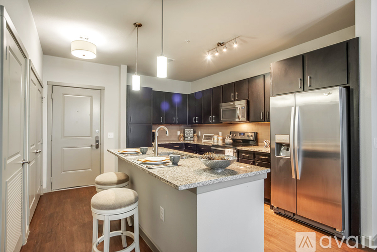 A kitchen with a white counter and a stainless steel refrigerator.