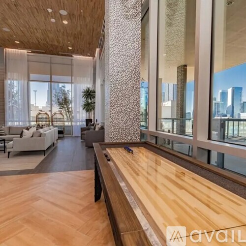 A spacious room with a long wooden table and a view of the city through large windows.