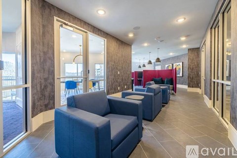 A living room with blue couches and a red couch in the background.