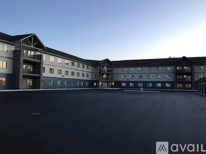 A large, modern building with a spacious parking lot in front.