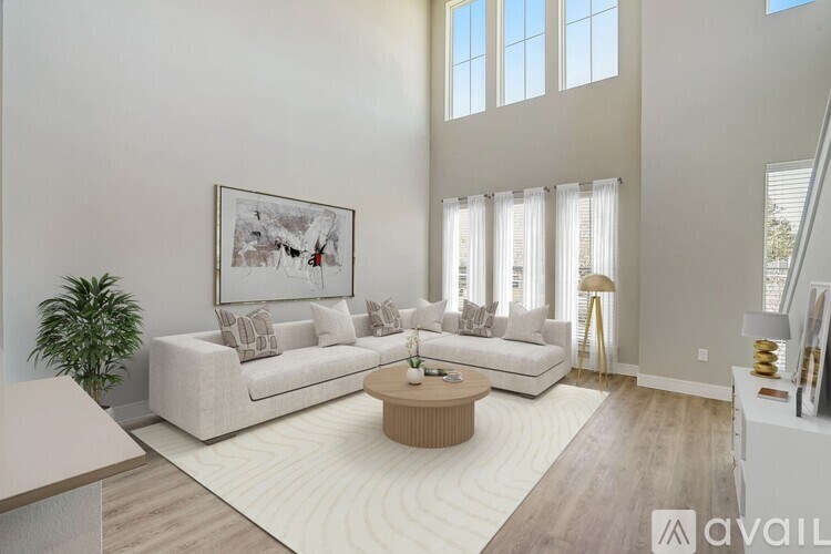 A living room with a white couch, a coffee table, and a painting on the wall.