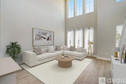 A living room with a white couch, a coffee table, and a painting on the wall.