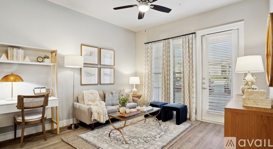 A living room with a sofa, a chair, a table, and a rug.