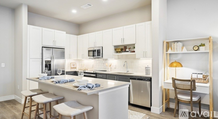 A modern kitchen with white cabinets and stainless steel appliances.