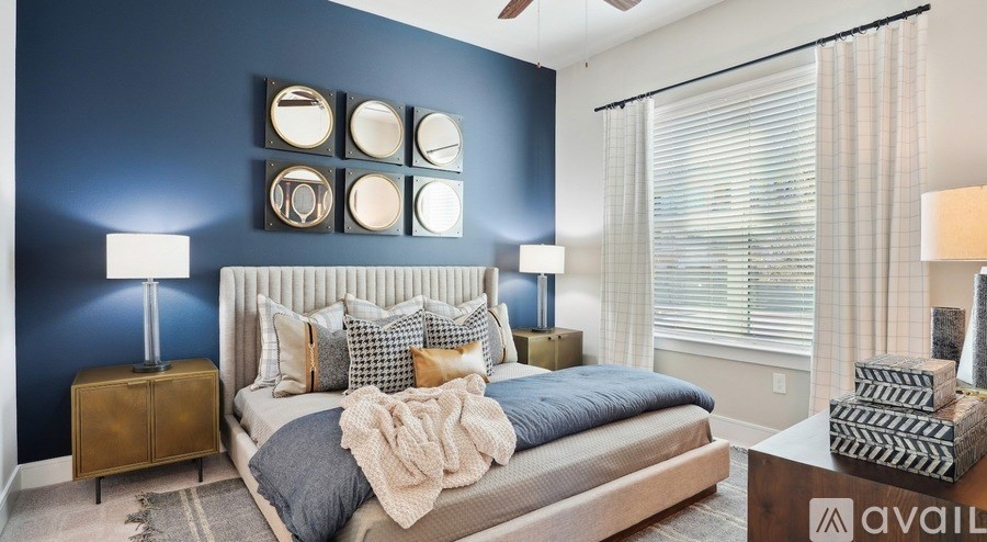 A bedroom with a bed, two lamps, and a wall decoration.