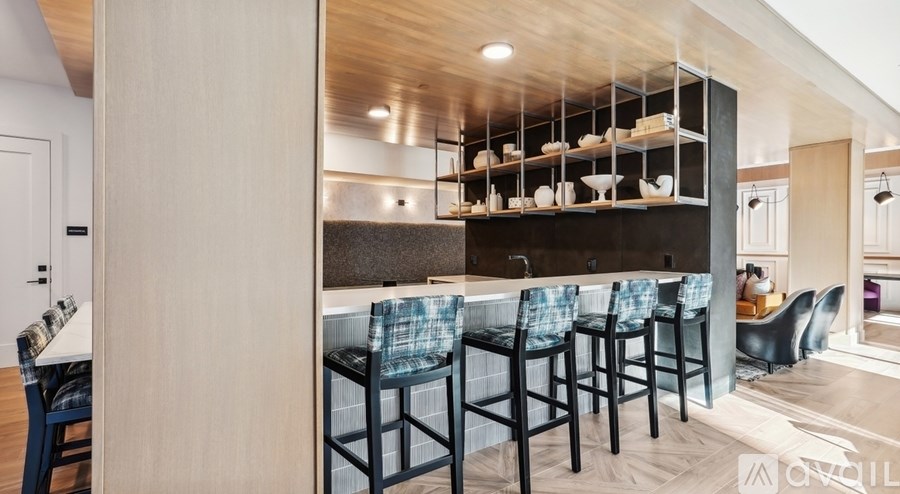 A modern kitchen with a bar area and chairs.