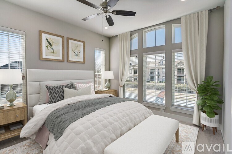 A bedroom with a large bed and a ceiling fan.