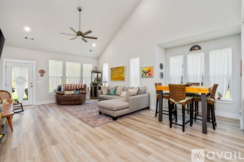 A spacious living room with a dining table and chairs.
