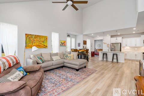 A living room with a brown couch and a rug in the middle.