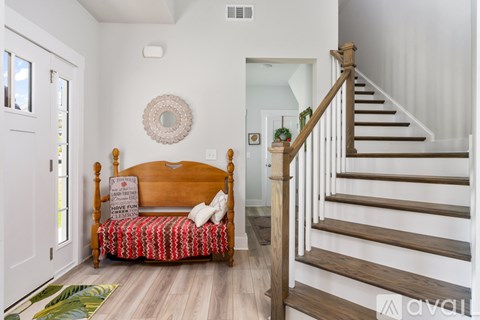 A wooden bench with a sign on it is in the foreground of a hallway.