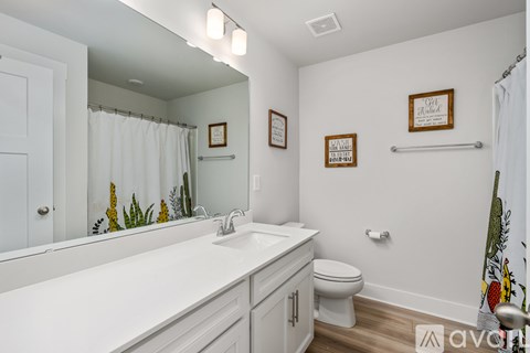 A white bathroom with a toilet, sink, and mirror.
